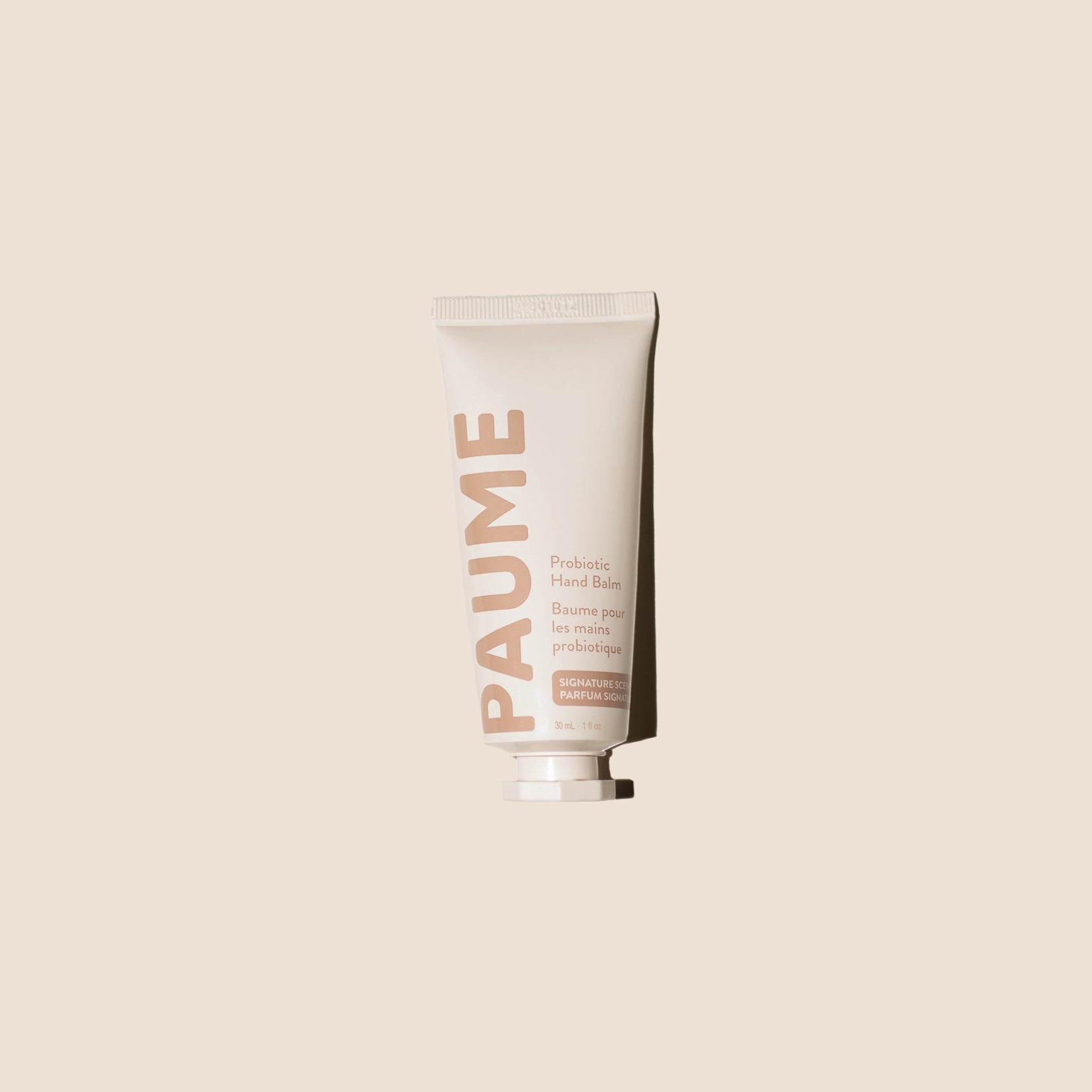 PAUME hand balm tube on a beige background