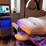 A hydrafacial machine beside a facial bed in a spa. 