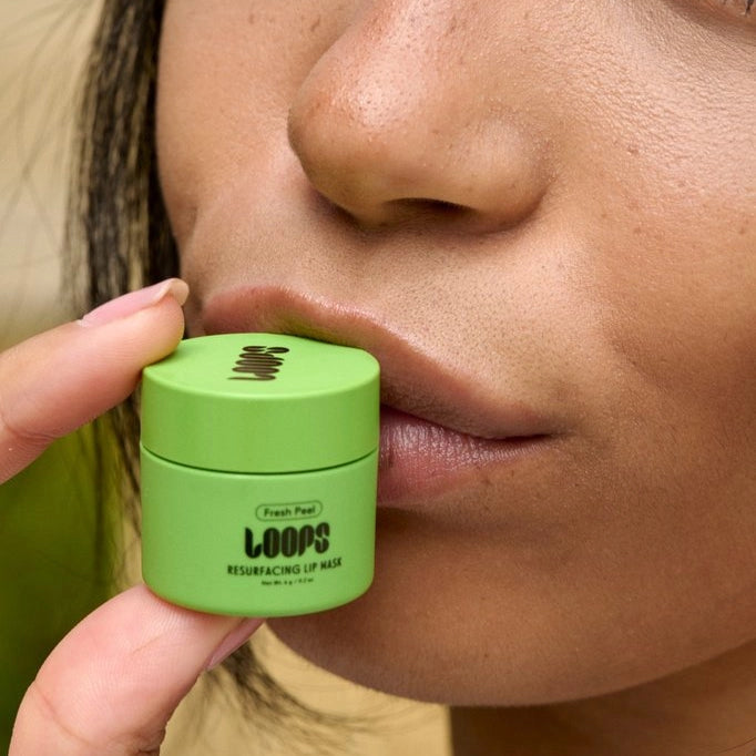 Person applying a green lip mask to their lips with a close-up view.