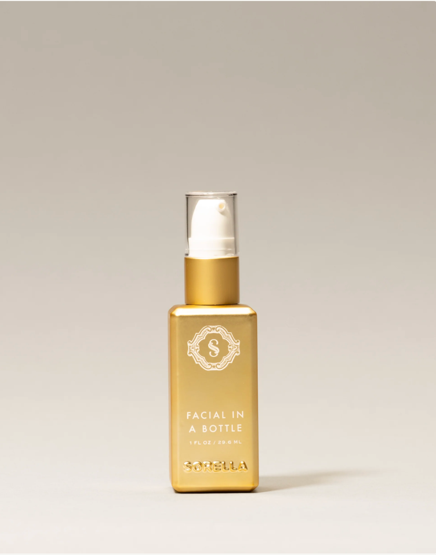 A gold serum bottle on a cream backgound. 