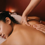 Person receiving a massage with a warm, reddish-brown background